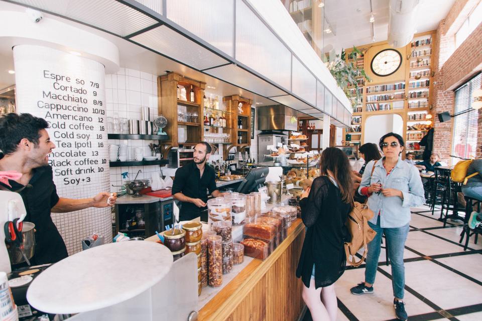 Mostrador de una cafetería con clientes siendo atendidos